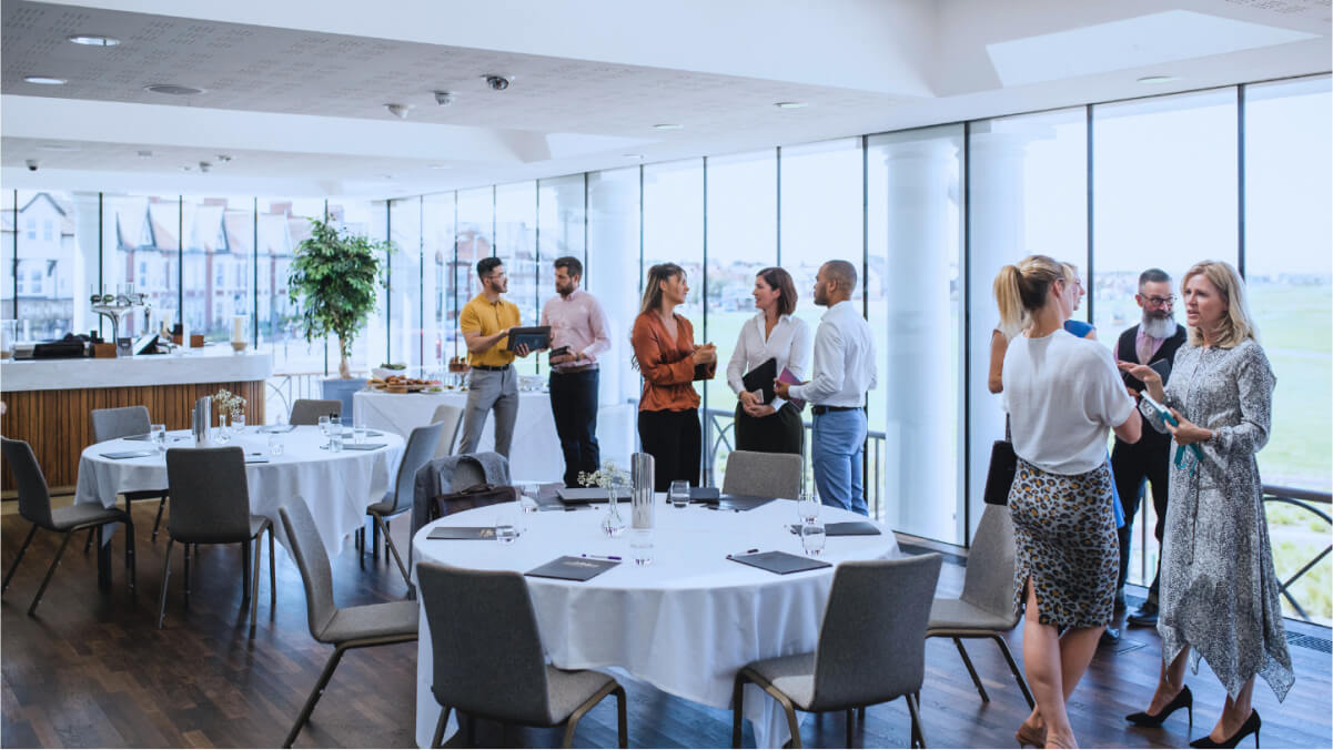 A group of people standing around a round table