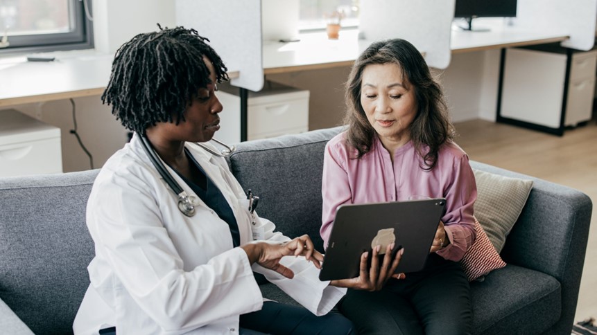 a doctor showing a patient a tablet screen