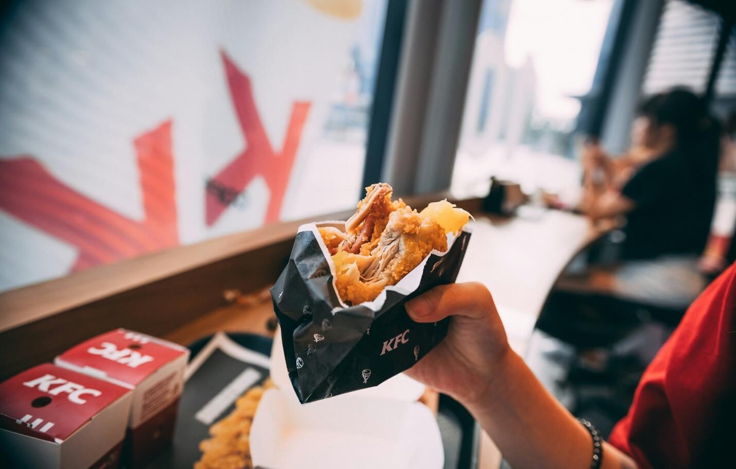 Hand holding a food in a paper bag