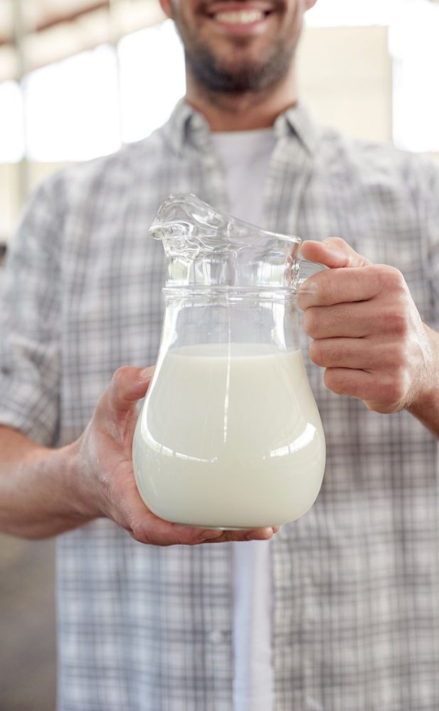 a man holding galas of milk