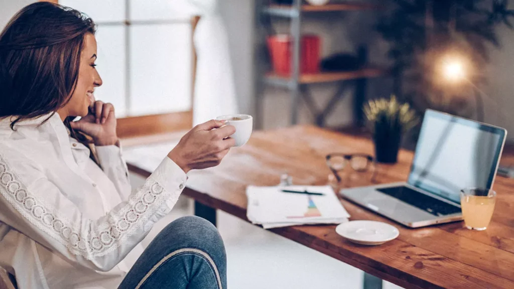 Woman drinking coffee in her home office