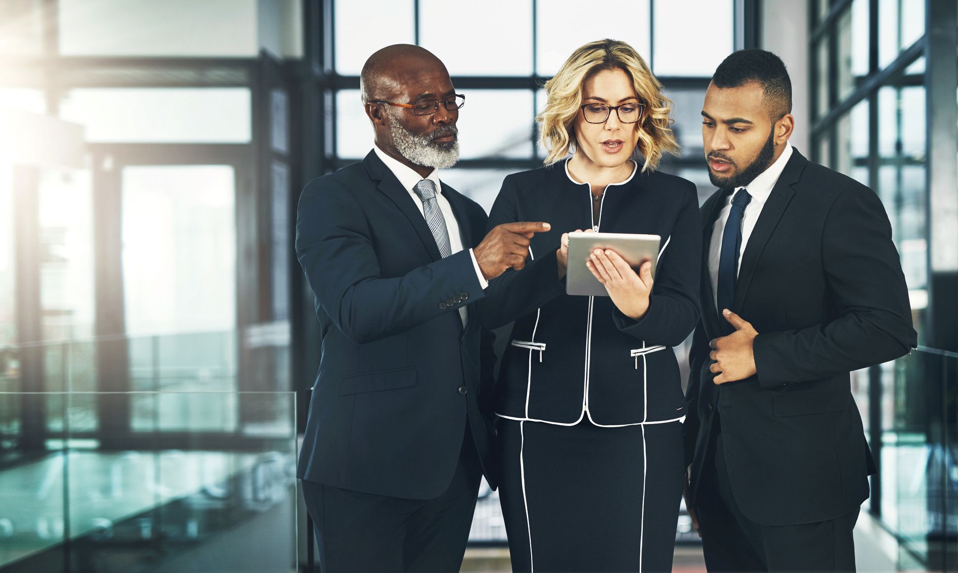 Three business professionals looking at a tablet