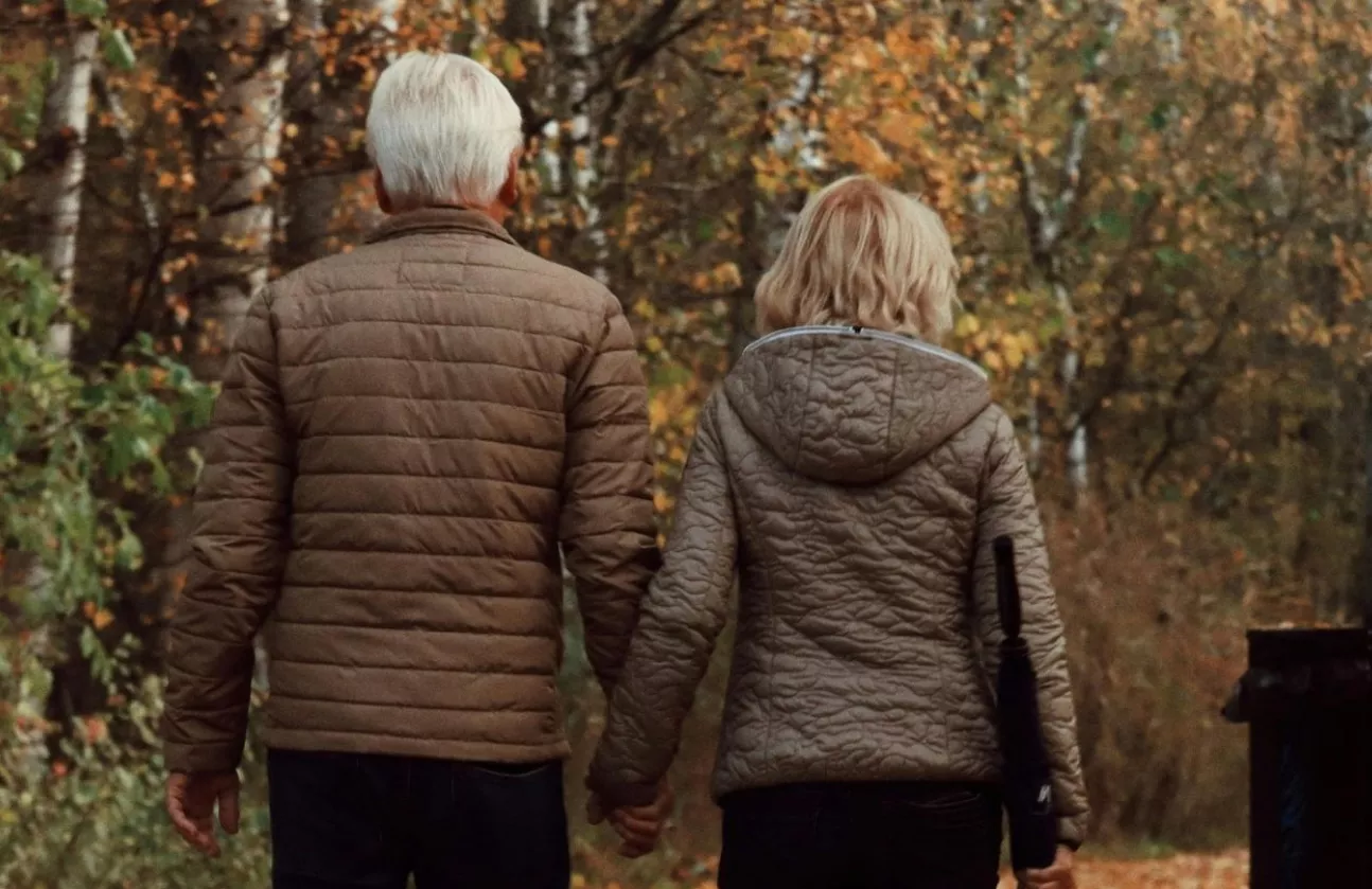 An elderly couple enjoys a morning walk
