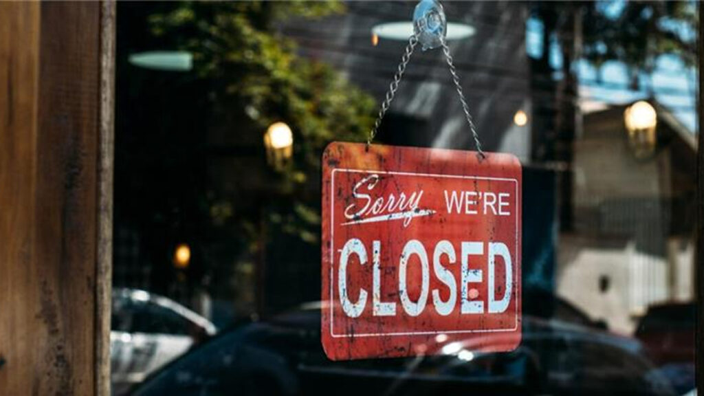 Closed signage hanging in the glass window