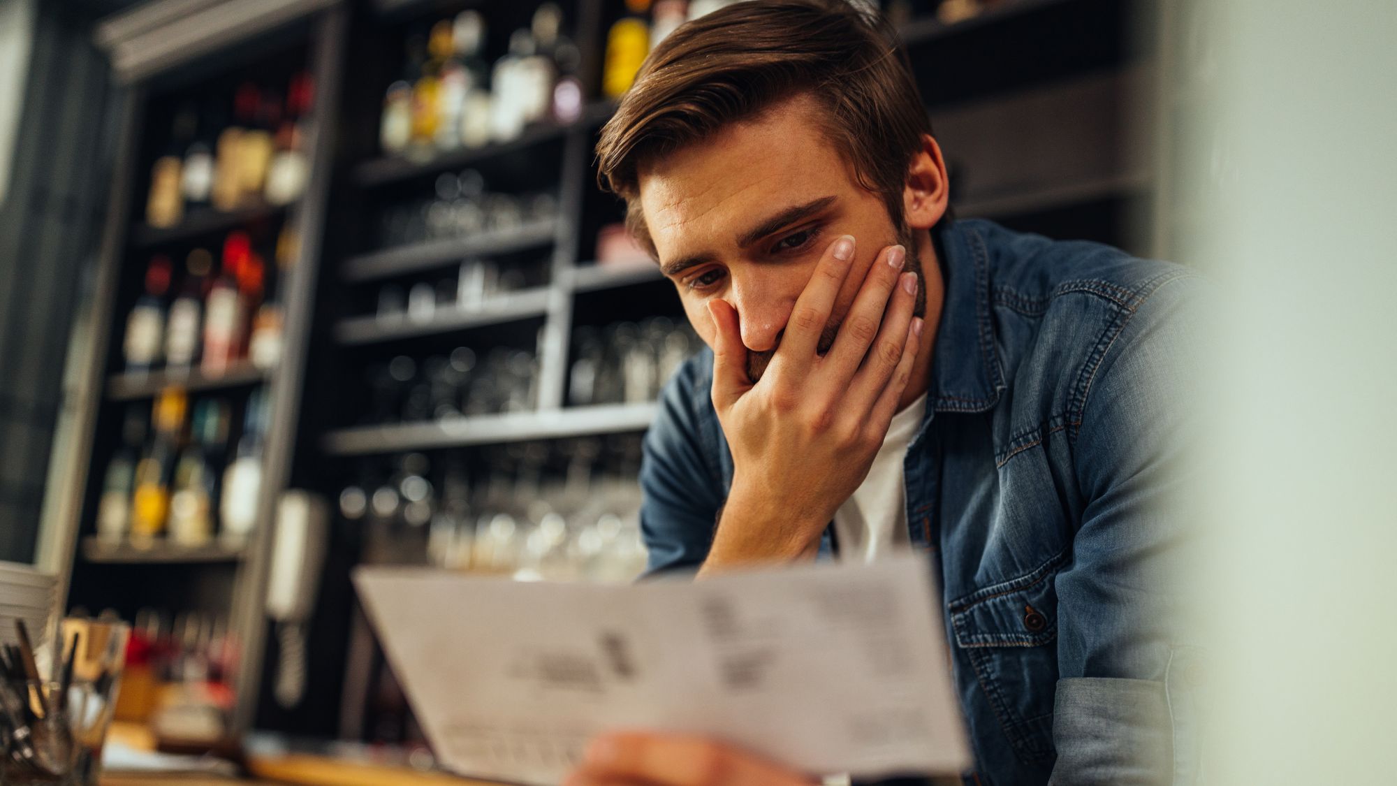 A man looking shocked while reading a paper