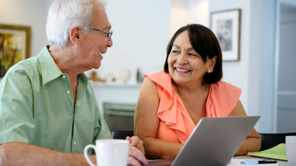 A smiling elderly couple looking warmly at each other