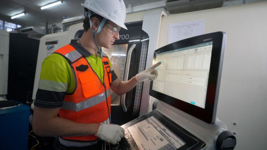 A worker is analyzing data displayed on the screen