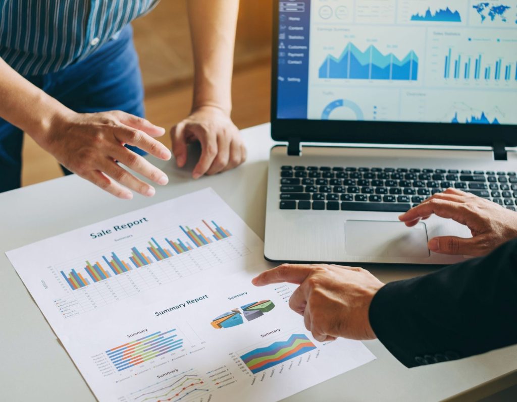 Sales report on a laptop and in printed paper