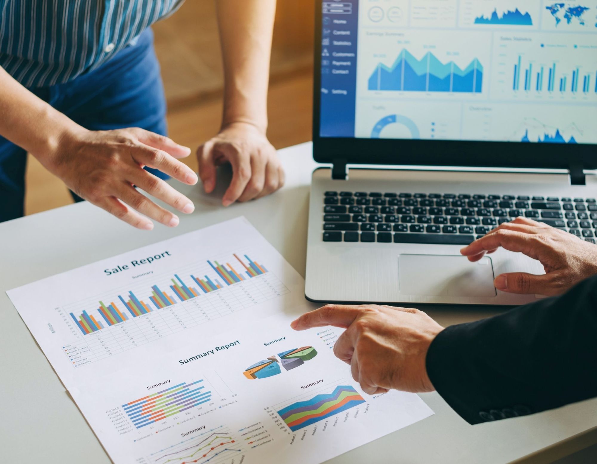 Sales report on a laptop and in printed paper