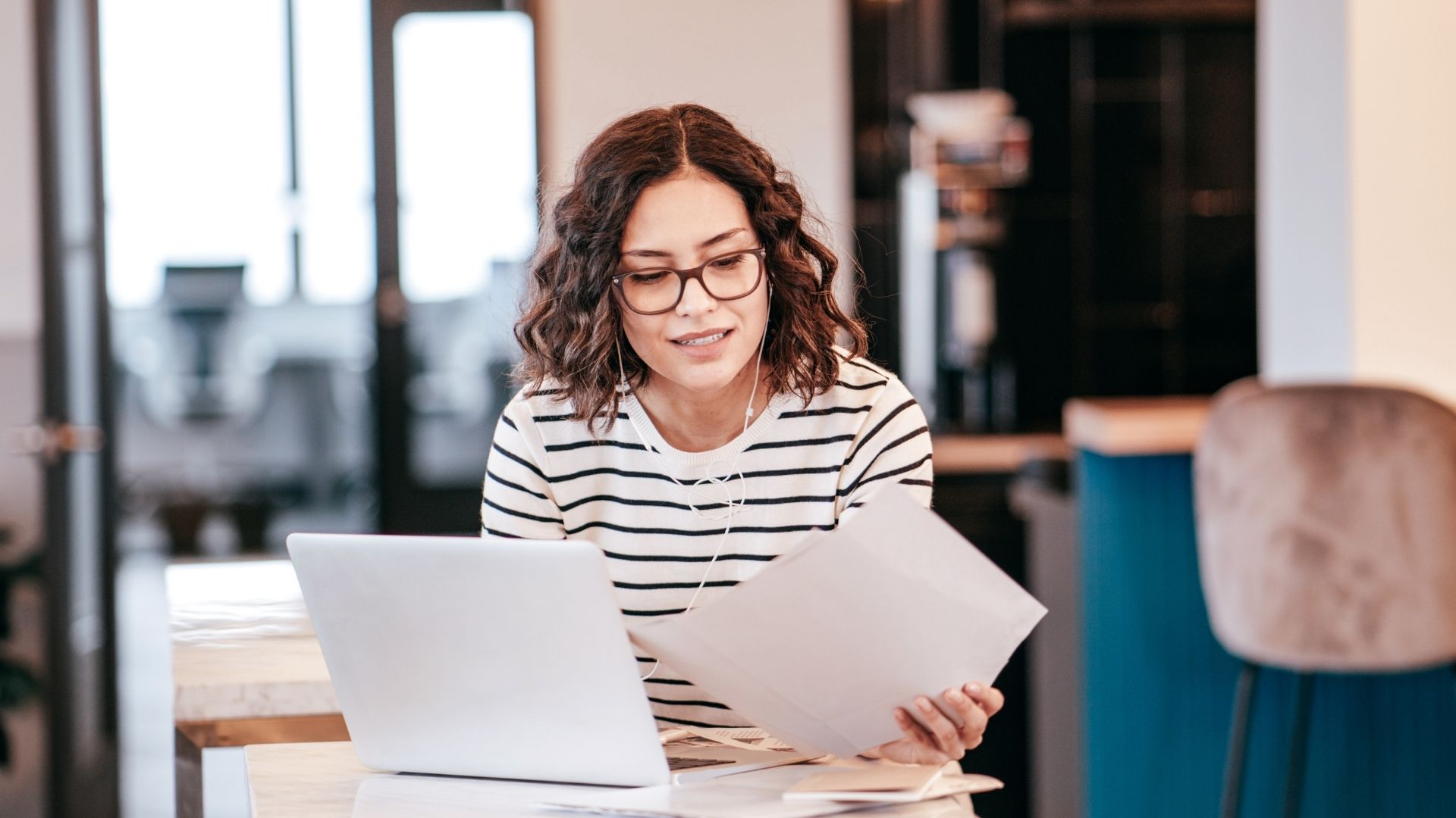 Woman Looking at the Laptop and Paper