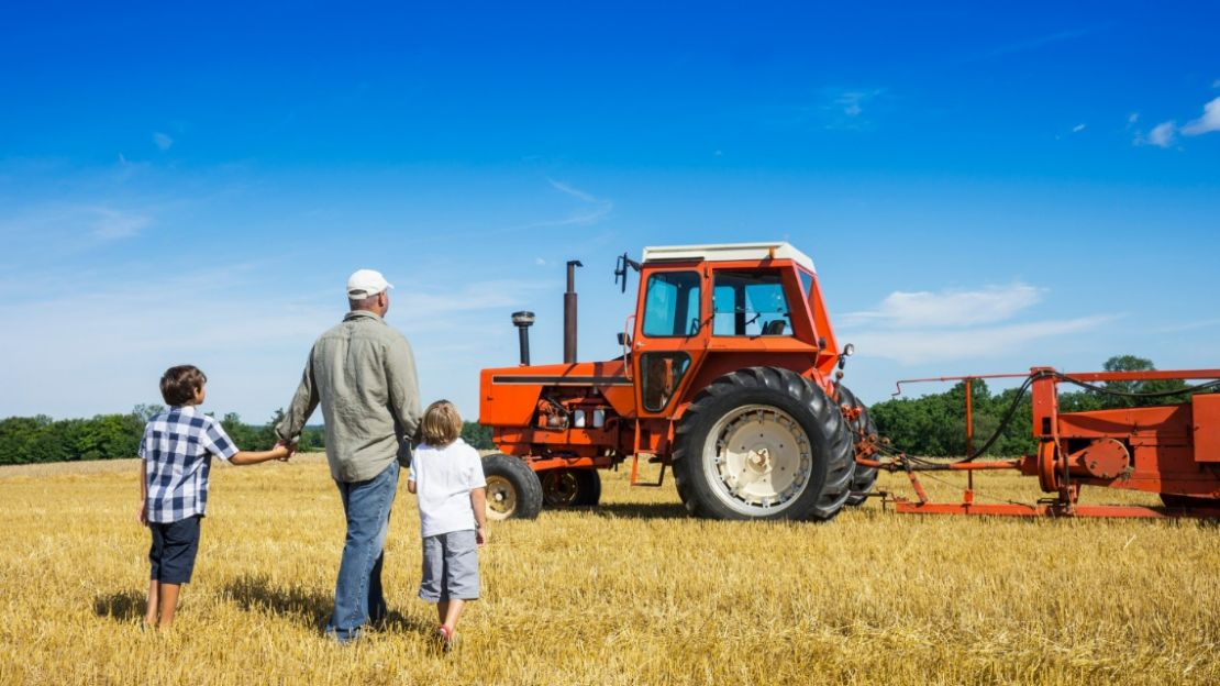 Father and Two Sons Looking at a Tractor